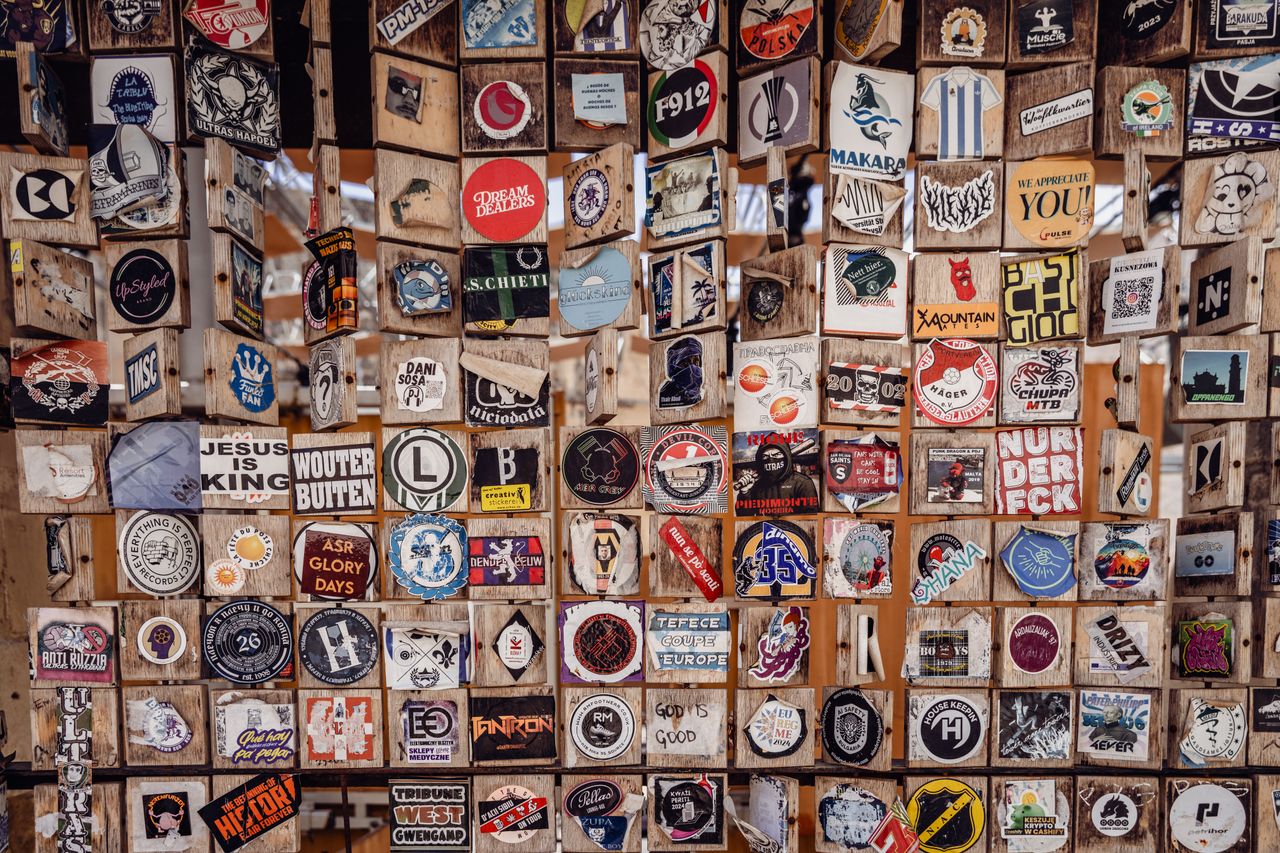 A vibrant assortment of stickers displayed on wooden panels in Valletta, Malta.